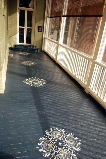 an empty porch with sun shining through the windows and decorative designs on the wood floor