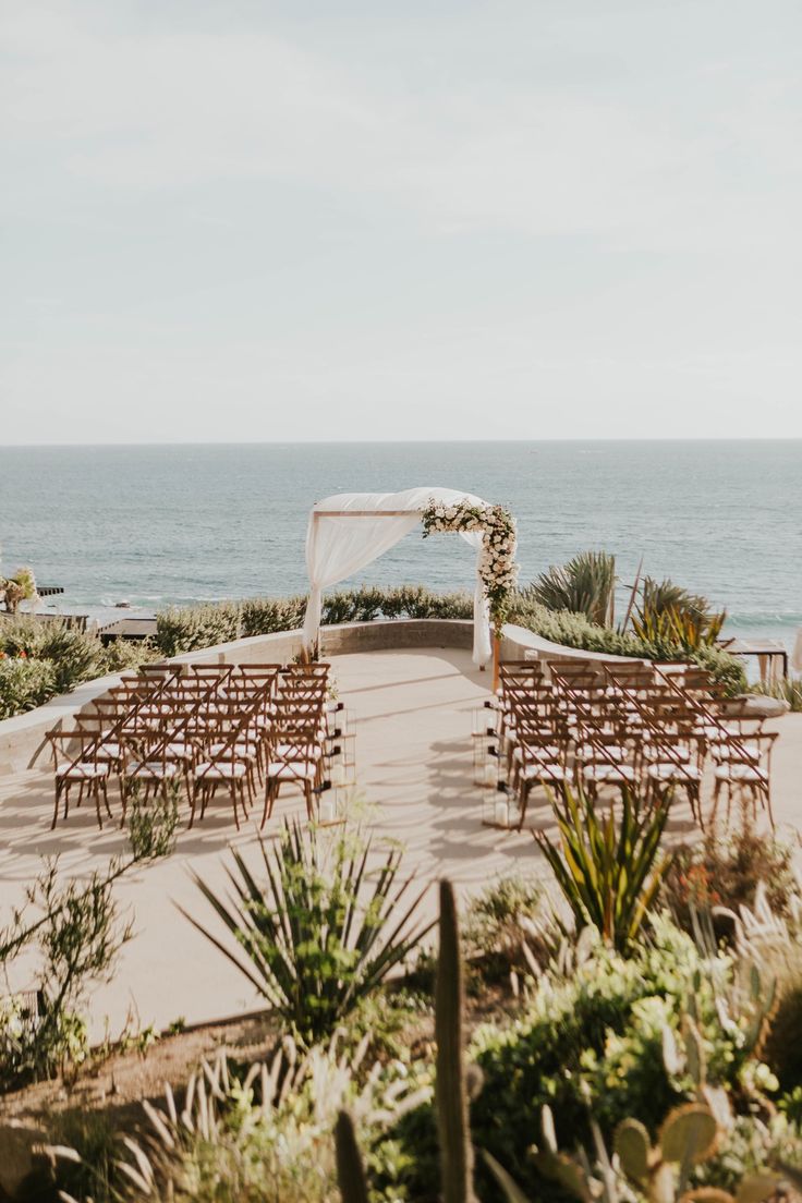 an outdoor ceremony set up by the ocean