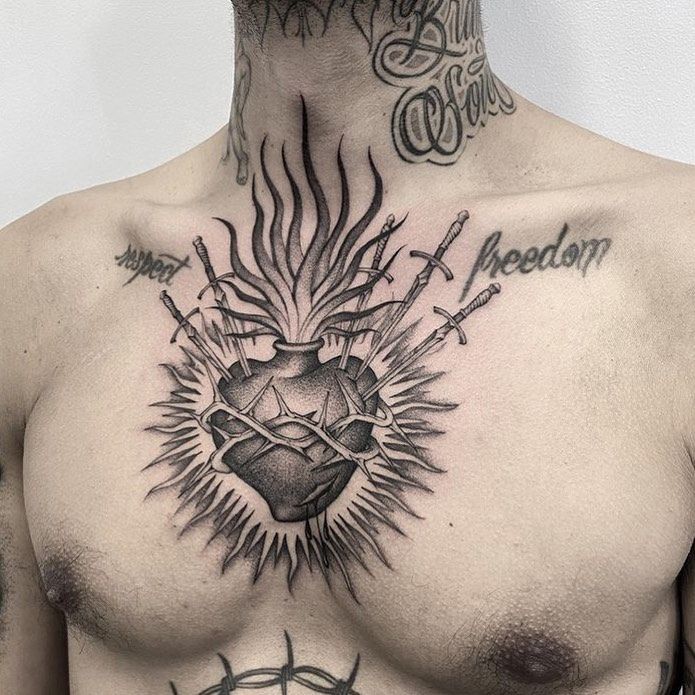 a man with tattoos on his chest has a heart and barbed wire around it's neck