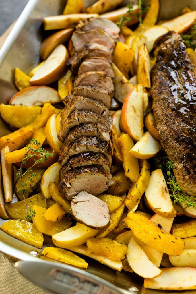 a roasting pan filled with meat, potatoes and carrots