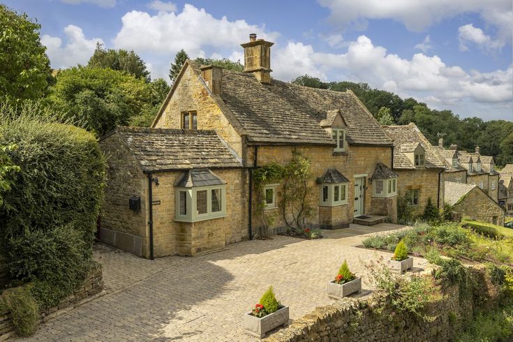 an old stone house surrounded by greenery and trees