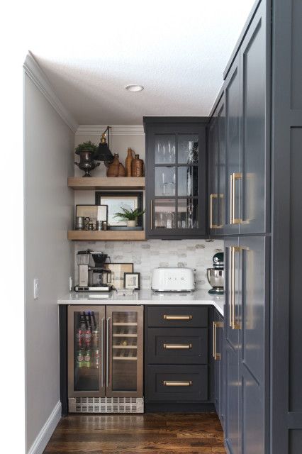 a kitchen with gray cabinets and wood floors