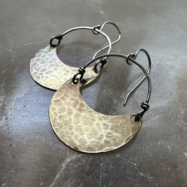 Over the years, my Crescent earrings have become our most popular and recognizable style! They are often the "first-pair" of earrings that people get for themselves or to gift another to start their collections. We make them in 4 sizes. Suspended from Sterling Silver wire and Sterling Silver earwires. Regardless of which size you choose, they are all amazingly lightweight and perfect as your "every day" earrings! Tiny = 3/4" wide x 1/2" tall & hang 1 3/8" from earwire to the bottom of the cresce Hand Forged Metal Earrings, Hand Forged Vintage Jewelry, Vintage Hand Forged Round Jewelry, Pierced Metal Jewelry For Anniversary, Crescent Hammered Earrings, Hammered Metal Jewelry For Anniversary, Hand Forged Oval Metal Jewelry, Modern Hand Forged Bronze Earrings, Hand Forged Earrings For Anniversary