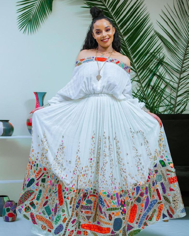 This stunning Habesha kemis is a true masterpiece of Ethiopian fashion. The luxurious Menen fabric drapes elegantly over the body, hugging every curve and creating a flattering silhouette. The intricate Tilf design adorns the neckline and hem of the dress, adding a touch of sophistication and cultural significance. The embroidery is done with care and precision, showcasing the skill and artistry of Ethiopian artisans. But what truly sets this Habesha dress apart is the addition of gorgeous beads Enku Design Dress, Ethiopian Fashion, Eritrean Dress, Ethiopian Clothing, Habesha Dress, Ethiopian Traditional Dress, Ethiopian Jewelry, Ethiopian Dress, Habesha Kemis