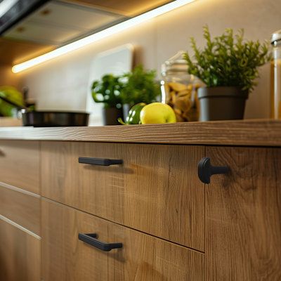 a kitchen with wooden cabinets and black handles