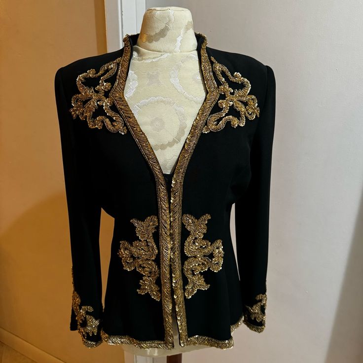 This Jacket Is Exquisite! Every Bead Meticulously Placed Masterfully Tailored! Sooo Gorgeous! Gold Sequins, Seed Beads & Round & Oval Gold Toned Beads. Small Shoulder Pads, Fully Lined. Has A Gold Bib That Can Be Removed From Snaps. Hidden Snap Closure. Excellent Condition. *Please See All Photos As Part Of Description.* Smoke Free Home. Elegant Fall Outerwear With Gold Embroidery, Elegant Embellished Festive Outerwear, Elegant Long Sleeve Outerwear With Gold Embroidery, Festive Embellished Evening Blazer, Festive Evening Embellished Blazer, Elegant Embellished Black Outerwear, Elegant Blazer With Gold Embroidery For Party, Elegant Fitted Hand-embellished Outerwear, Elegant Black Embellished Outerwear