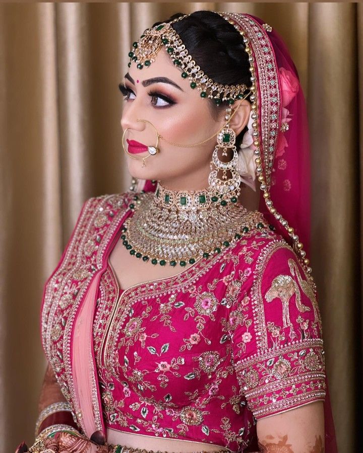 a woman in a pink and gold bridal outfit