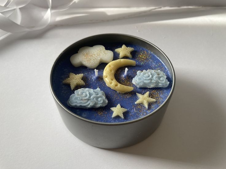 a tin with some cookies in it on top of a white table next to a ribbon