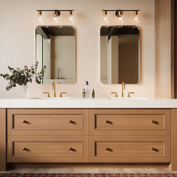 two bathroom sinks with mirrors above them and a rug on the floor next to them