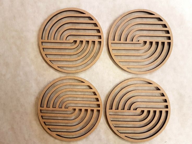 four circular wooden coasters sitting on top of a table next to each other in the shape of a spiral