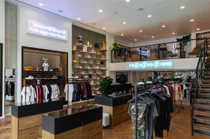 the inside of a clothing store with clothes on racks