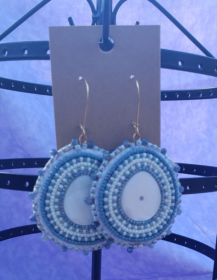 I have no idea how to describe this shape. I love it so much but I do not know how to talk about it. This is very similar to my white diamond shell earrings with pearls and sapphires but bigger and with only sapphire beads. The bead in the center of the shell is the lined bead that is used in the earring. Bohemian Beaded Embroidered Earrings For Festivals, Handmade Artisan Blue Beaded Earrings, Adjustable Bohemian Beaded Round Earrings, Artisan Blue Beaded Round Earrings, Bohemian Turquoise Beaded Round Earrings, Bohemian Blue Beaded Earrings With Tiny Beads, Bohemian Blue Macrame Earrings, Blue Bohemian Macrame Earrings, Blue Macrame Bohemian Earrings