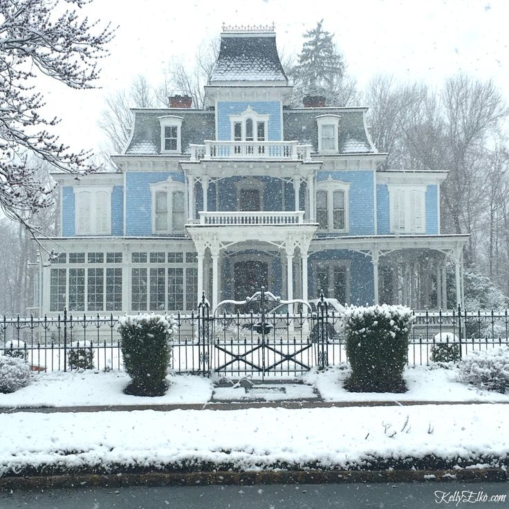 a large blue and white house covered in snow