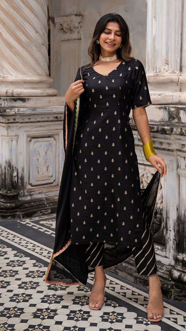 Bring on the festive spirit with our silk kurta set Made in woven silk with golden zari Fully lined kurta and pants Dupatta made in Chiffon with Gota border Color : Black + Gold Model height is 5.6” and is wearing a size M Wash Care : Dry Clean Only Churi Pant Designs, Black Palazzo Set With Zari Work For Diwali, Festive Black Palazzo Set With Zari Work, Diwali Black Palazzo Set With Zari Work, Bollywood Style Black Palazzo Set For Festive Season, Bollywood Style Black Palazzo Set For Festive Occasions, Festive Bollywood Style Black Palazzo Set, Black Zari Work Palazzo Set For Festivals, Festive Black Chanderi Salwar Kameez