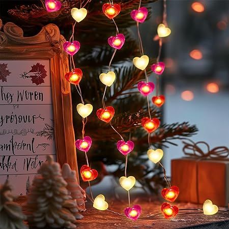 a christmas tree decorated with lights next to a sign