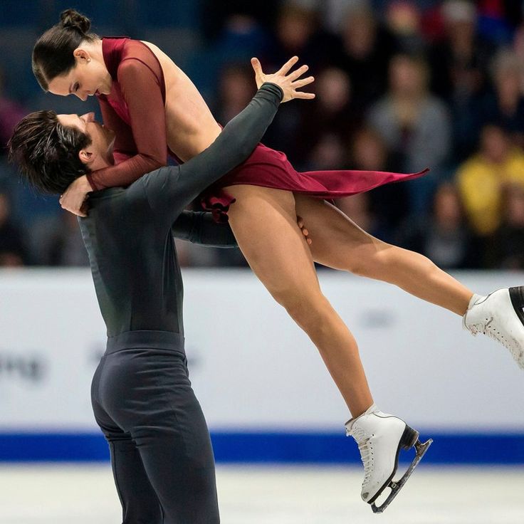 two people are skating on an ice rink