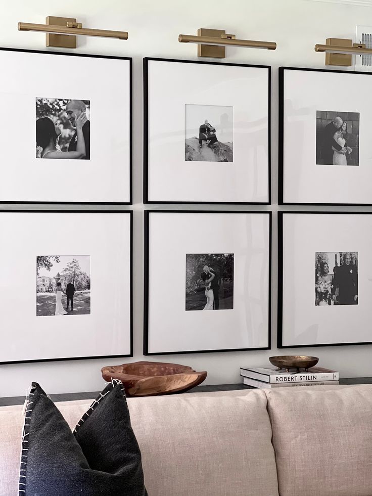 black and white photographs hang on the wall above a couch