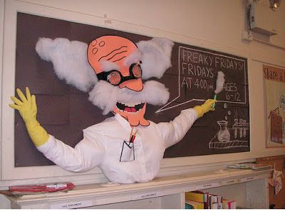 a man dressed as an old scientist in front of a chalkboard