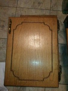 a wooden box sitting on top of a tile floor next to a toilet paper dispenser