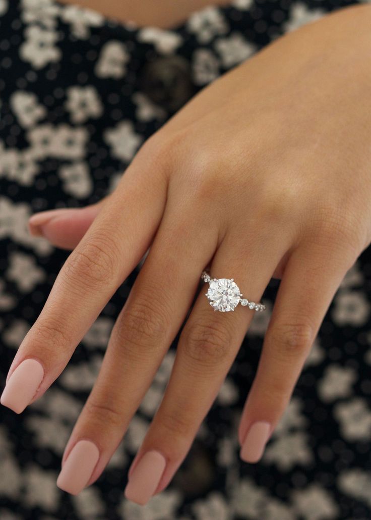 a woman's hand with a diamond ring on it