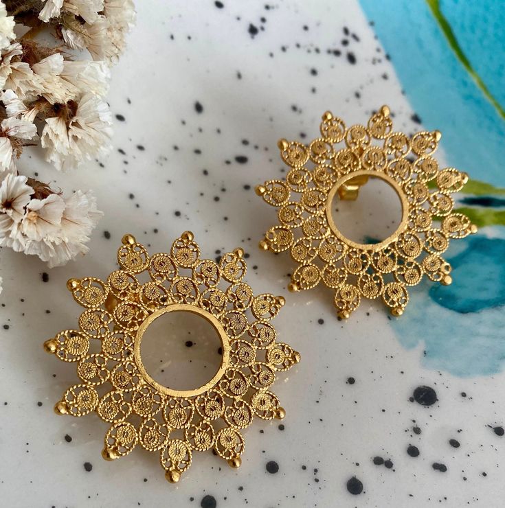 Discover these exquisite handmade filigree earrings, crafted in sterling silver and plated with 24k gold. With a beautiful Sun design, these earrings are the perfect accessory to add an elegant and sophisticated touch to any outfit. Ideal for special occasions such as weddings, parties, or to stand out in everyday wear. Each piece is carefully handcrafted using traditional techniques, creating a unique piece of jewelry that reflects the art and history of filigree. Gold Bridal Earrings With Intricate Design As Gift, Gold Earrings With Intricate Design For Gift, Gold Filigree Earrings As Gift, Yellow Gold Brass Bridal Earrings For Gift, Gold Plated Bridal Earrings As Gift, Delicate Earrings With Intricate Design For Gift, Handmade Gold Plated Bridal Earrings For Celebration, 22k Gold Bridal Earrings As Gift, Artisan Gold Earrings With Intricate Design