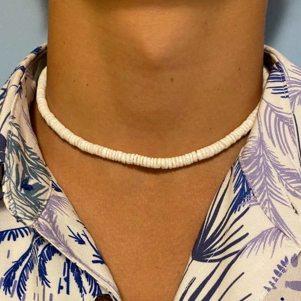 Experience the exotic beauty of the Elios White Shell Puka style Men Necklace! Made in the USA. This 14Kt gold-filled necklace is 16-17" long and sure to bring you seaside vibes wherever you are. A stylish addition to any look, its perfect for a beach day or a casual evening. Live seaside living with this unique statement piece! Puka Shell Necklace Men, Adjustable Single Strand Jewelry For Vacation, Adjustable Single Strand Necklace For Vacation, Minimalist Beach Choker Jewelry, Minimalist Adjustable Necklaces For Beach, White Single Strand Necklace For Beach, Single Strand Choker Necklace For Beach, Seashell Necklace Diy, Puka Shell Necklace