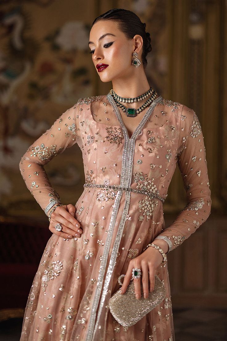 Vivienne exudes luxury with its double-layered peshwaas featuring an embroidered organza outer layer and a printed silk inner. Paired with a printed blouse and lehenga, it's a flawless fusion of elegance and charm. Elegant Hand Embellished Maxi Sets, Eid Anarkali Hand-embellished Sets, Festive Hand Embellished Maxi Sets, Festive Hand Embellished Organza Sets, Floor-length Hand Embellished Organza Anarkali Set, Hand Embellished Floor-length Organza Anarkali Set, Formal Party Wear Choli With Resham Embroidery, Hand Embellished Party Wear Lehenga For Eid, Formal Choli With Resham Embroidery