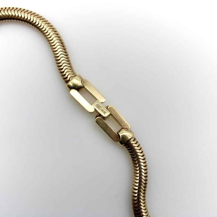 This is part of Chairish’s Fine Jewelry assortment.  Made from beautiful 14k gold, this vintage snake chain is the perfect length for a slinky choker necklace. With a width of 5 mm, this is a wonderfully thick chain with substantial presence on the neck. Perfect alone or layered, it makes for a great minimalist look. It’s also a great chain for a bold charms with large bails or charm extenders.   Circa the 1970’s, the chain is in great condition with no kinks or wear. It has a secure fold-over c Formal Necklace With Lobster Clasp And Snake Chain, Classic Herringbone Necklace With Box Chain For Formal Occasions, Formal Snake Chain Necklace With Lobster Clasp, Classic Yellow Gold Snake Chain Necklace, Elegant Herringbone Chain Choker Necklace, Elegant Gold Metal Snake Chain Necklace, Yellow Gold Herringbone Necklace For Formal Occasions, Formal Yellow Gold Herringbone Necklace, Polished Snake Chain Necklace For Formal Occasions