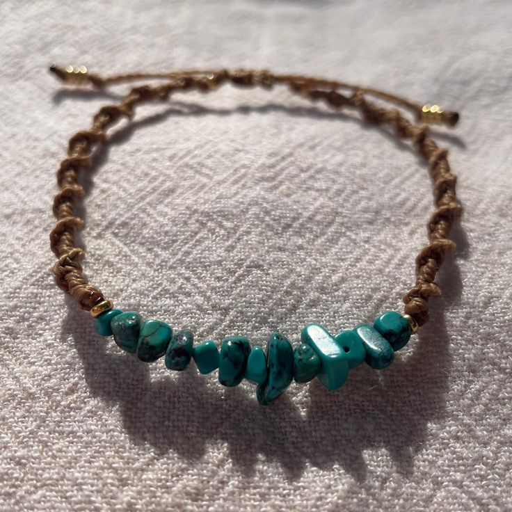 a beaded bracelet with turquoise beads on a white cloth