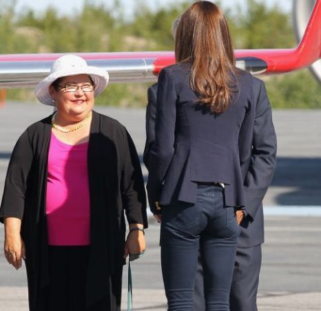 two women are standing in front of an airplane