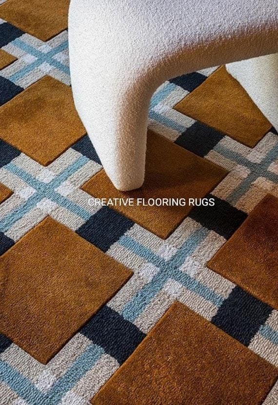 a white chair sitting on top of a checkered floor next to a brown and blue rug