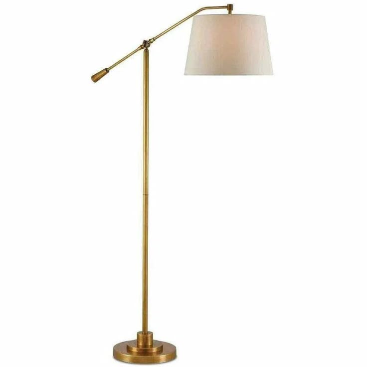 a floor lamp with a white shade on the top and a gold metal base,