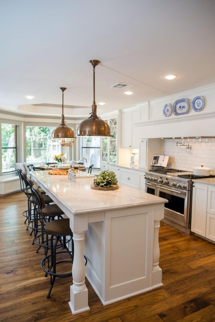 a large kitchen with an island in the middle and lots of counter space on one side