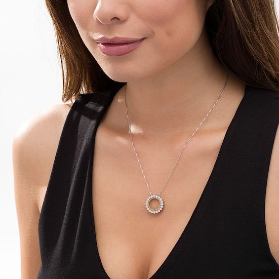 Complement any attire with this stunning diamond circle pendant. Fashioned in sterling silver and 14K gold plate, this open circle shimmers with diamonds - each artfully set to enhance size and sparkle. A gold-plated rope-textured border gleams along the inside. Radiant with 1/20 ct. t.w. of diamonds and a brilliant buffed luster, this pendant suspends along an 18.0-inch box chain that secures with a spring-ring clasp. Fine Jewelry Diamond Necklace With Halo For Anniversary, Elegant Silver Full Circle Necklace, Halo Open Circle Necklace, Modern Open Circle Jewelry For Anniversary, Elegant Open Circle Cubic Zirconia Jewelry, Fine Jewelry Circular Cubic Zirconia, Modern White Gold Jewelry With Halo Setting, Cubic Zirconia Open Circle Halo Jewelry, Elegant Cubic Zirconia Circle Jewelry