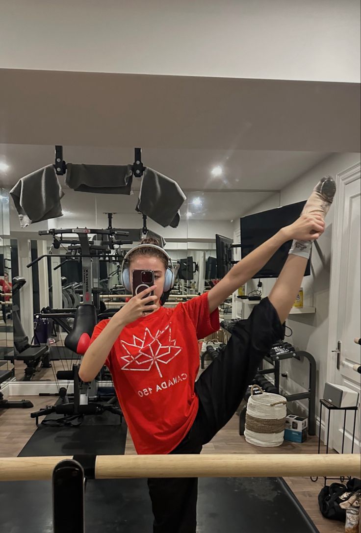 a man is taking a selfie in the gym with headphones on while holding his cell phone