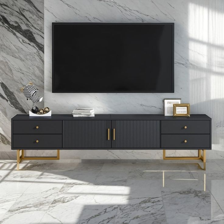 a large television mounted to the side of a wall next to a black and gold cabinet