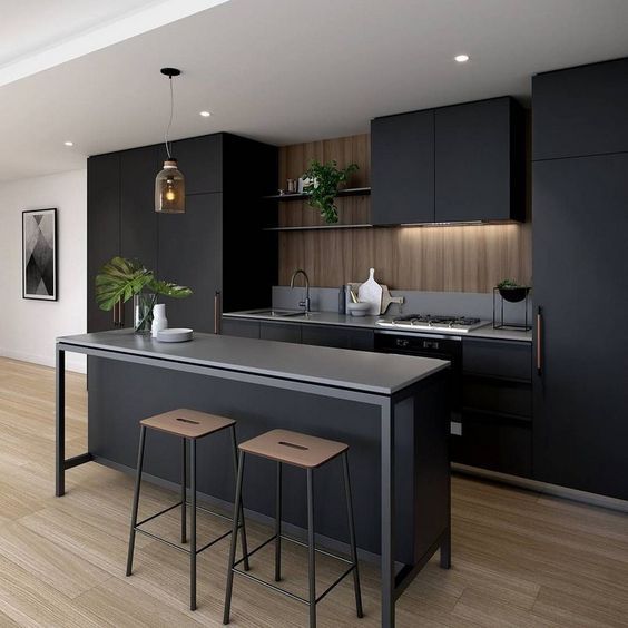 an open kitchen with black cabinets and counter tops, two stools in front of the island