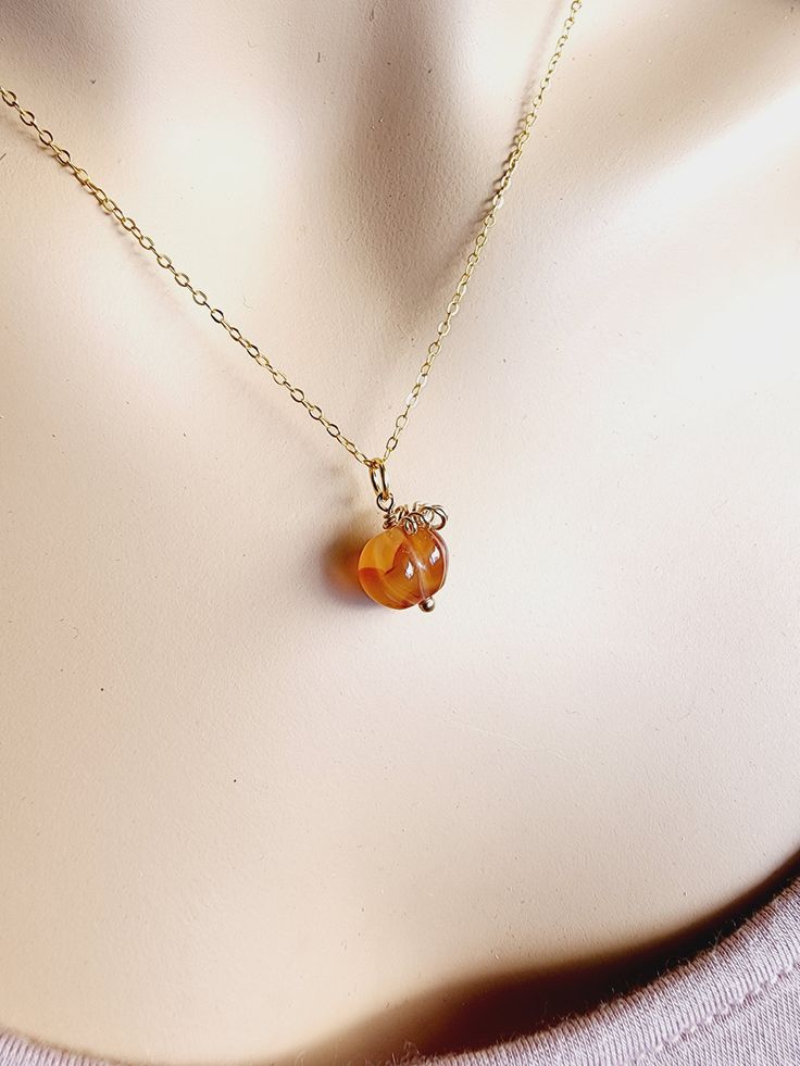 The Great Pumpkin has arrived! This adorable mini pumpkin necklace is wire wrapped with your choice of 14k gold filled, sterling silver or antique brass. The gemstone necklace is hand carved in the shape of a pumpkin. This dark orange carnelian gemstone necklace is available on your choice of chain length.►NOTE◄All pumpkins are randomly selected and will not be the exact one you see in the picture. Gemstones are natural and all will have some natural imperfections which makes your pumpkin gemsto Orange Gemstone Pendant Necklace, Orange Faceted Jewelry Gift, Orange Round Pendant Jewelry As Gift, Orange Round Pendant Jewelry Gift, Orange Round Pendant Jewelry For Gift, Yellow Gold Agate Necklace As Gift, Yellow Gold Agate Necklace For Gift, Orange Pendant Charm Necklaces For Gifts, Orange Gemstone Necklaces As A Gift