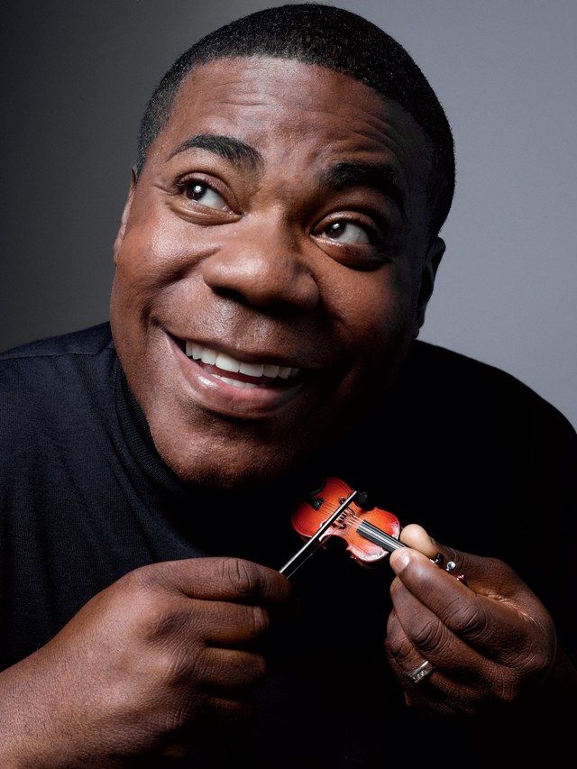 a man is holding a toothbrush in his right hand and smiling at the camera