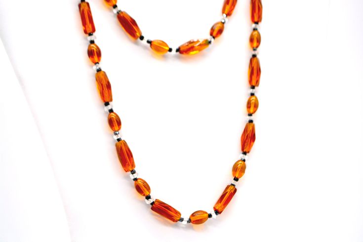 This wonderful vintage glass bead necklace features faceted amber orange beads mixed with black and clear beads. We've upgraded the original broken clasp but the beads are all original. Beads range from 2 to 19mm in length 33" long Weighs 1.8 ounces US SHIPPING: US orders over $35 ship free via first class mail. Orders over $200 receive a free priority mail upgrade. Expedited shipping is available. SHIPPING OUTSIDE THE US:  We combine shipping on multiple item orders.  Expedited shipping and ins Cheap Vintage Orange Beaded Necklaces, Clear Beads, Unique Packaging, Vintage Orange, Glass Bead Necklace, Vintage Costumes, Black Glass, Glass Bead, Bead Necklace