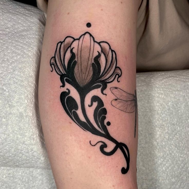 a black and white flower tattoo on the arm