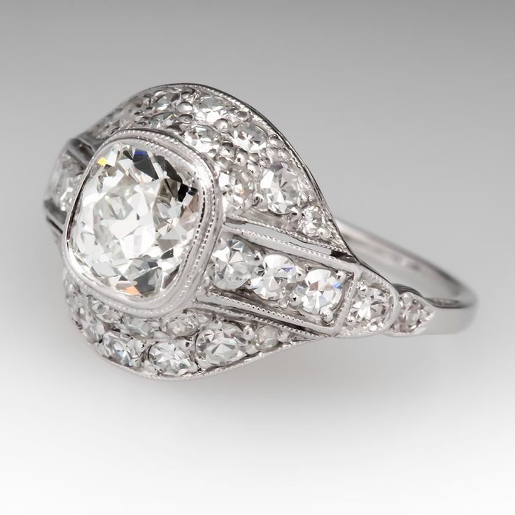 Circa 1930s ring is centered with one (1) old mine cut diamond set into a bezel. The gallery features a pierced design, bordered with milgrain edging and accented thirty-two (32), bead set, round single cut diamonds. The ring measures 11.5mm at the top, rises 5.4mm above the finger, tapering to 1.1mm wide and 0.8mm thick at the base of the shank. We offer complimentary ring sizing to fit. Platinum Art Deco Ring With Bezel Setting, Art Deco Diamond White Ring With Bezel Setting, Art Deco White Diamond Ring With Bezel Setting, Art Deco White Gold Diamond Ring With Bezel Setting, Vintage Diamond White Ring With Bezel Setting, Art Deco Diamond Ring With Bezel Setting, Vintage White Gold Diamond Ring With Bezel Setting, Classic Cushion Cut Ring With Bezel Setting, Vintage Diamond Ring With Bezel Setting