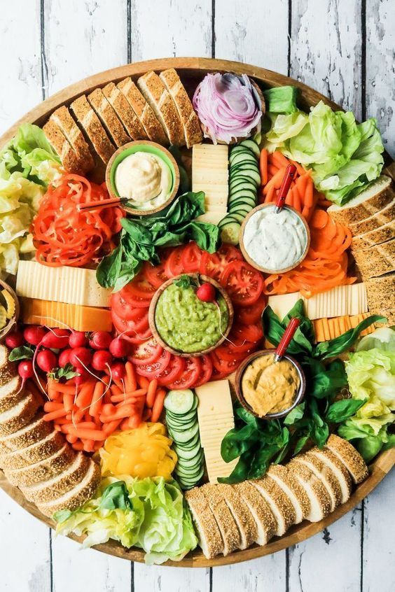 a platter filled with lots of different types of food on top of a wooden table