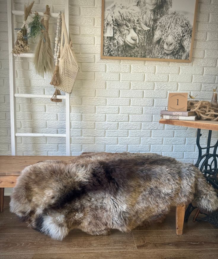 a sheepskin rug sitting on top of a wooden floor in front of a brick wall