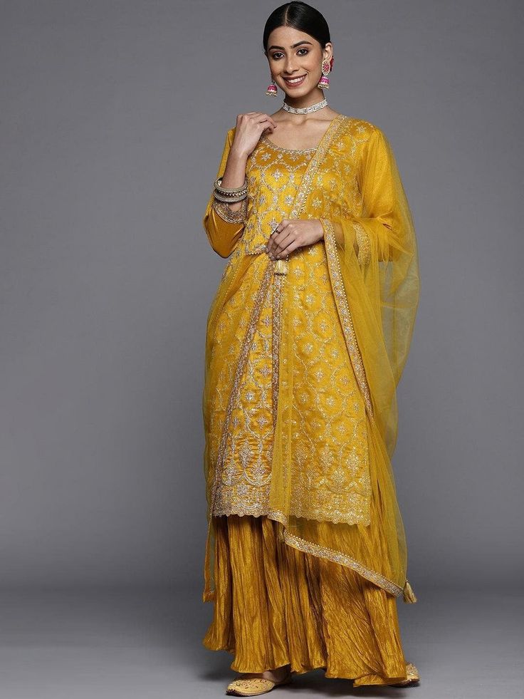 PRODUCT DETAILS  Mustard yellow embroidered Kurta with Sharara & dupatta Kurta design: Floral embroidered Straight shape Regular style Round neck, three-quarter regular sleeves Sequinned detail Calf length with scalloped hem Silk blend machine weave fabric Sharara design: Solid Sharara Partially elasticated waistband Slip-on closure 2 pocket Dupatta: Solid Tasselled border Size & Fit The model (height 5'8) is wearing a size S Dupatta: 2.7 x 1.1 meters (length x width) Material & Care Kurta: Silk Blend Bottom: Silk Blend Dupatta: Silk Blend Dry Clean Specifications Sleeve Length : Three-Quarter Sleeves Top Shape : Straight Top Type : Kurta Bottom Type : Sharara Dupatta : With Dupatta Top Pattern : Embroidered Top Design Styling : Regular Top Hemline : Scalloped Top Length : Calf Length Neck Elegant Yellow Embroidered Sharara, Semi-stitched Dresses With Gold Embroidery For Diwali, Festive Gold Embroidered Dress, Festive Anarkali Dress With Gold Embroidery, Gold Embroidered Dress For Eid, Festive Yellow Embroidered Dress, Eid Wedding Dress With Gold Embroidery, Diwali Anarkali Dress With Gold Embroidery, Fitted Gold Lehenga With Chikankari Embroidery