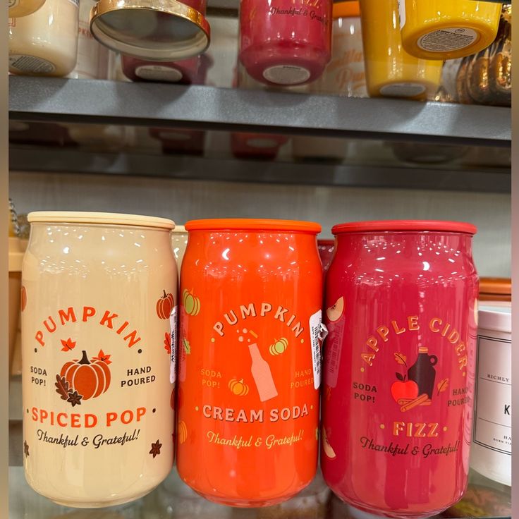 there are many different colored jars on the shelf in this store, one is for pumpkin spiced pop