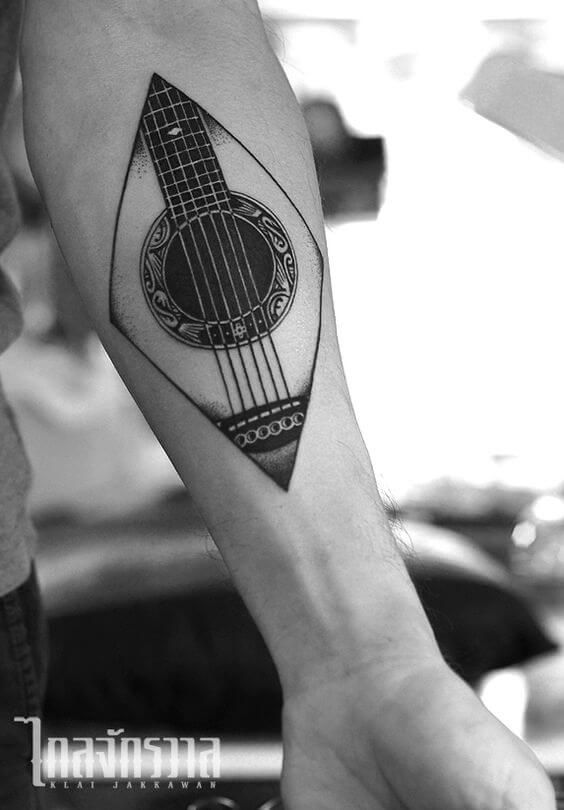 a man with a guitar tattoo on his arm