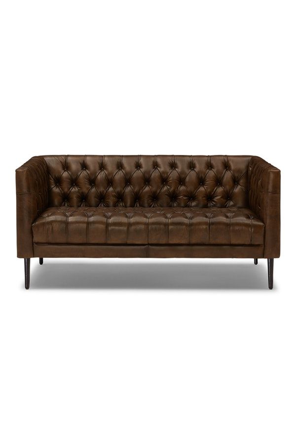 a brown leather couch with wooden legs and buttons on the back, against a white background