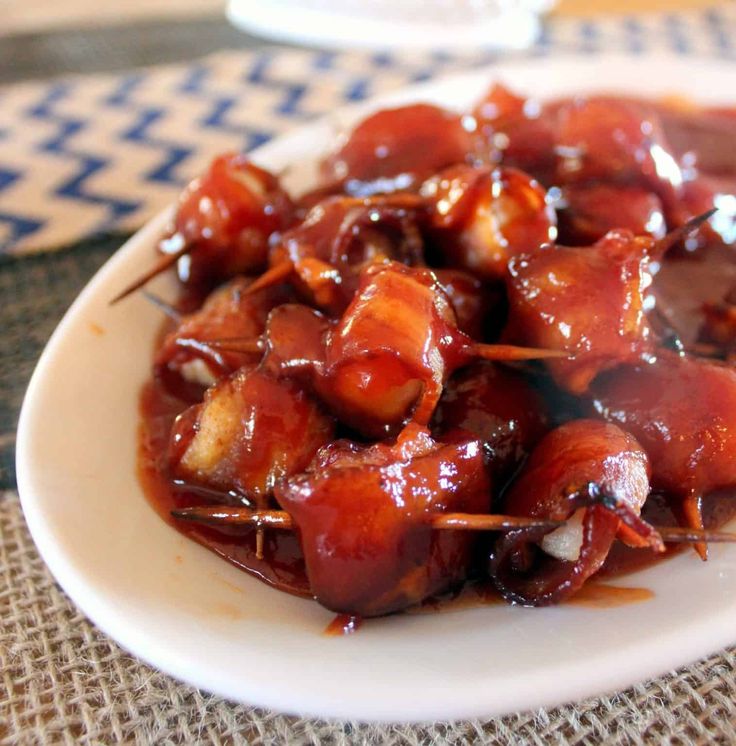 a white plate topped with meat covered in sauce and skewered toothpicks