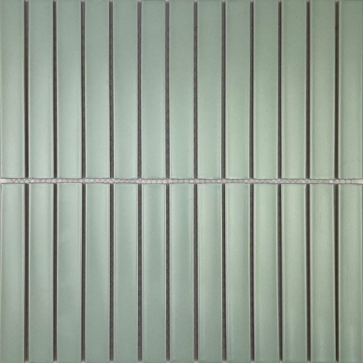 a green tile wall with vertical lines on it